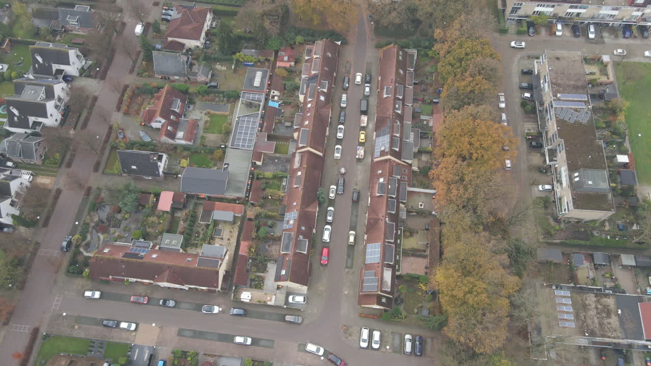 Riprese aeree dall'alto di un'auto bianca che percorre una piccola strada in un bellissimo quartiere residenziale