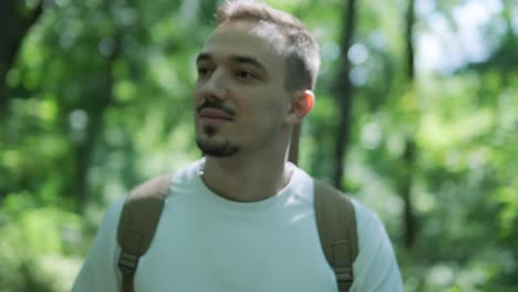 joven caminando con la guitarra en la calle cerca del bosque