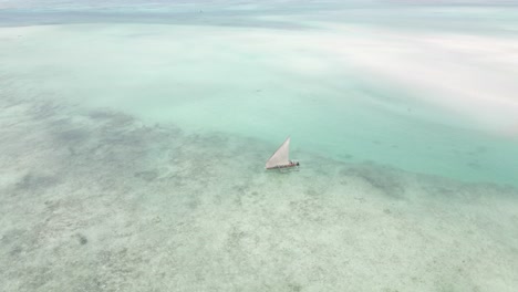 Drone-shot-of-small-wooden-boat-sailing-on-coast-of-Africa-in-ocean