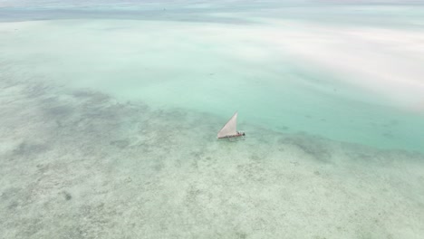 drone shot of small wooden boat sailing on coast of africa in ocean