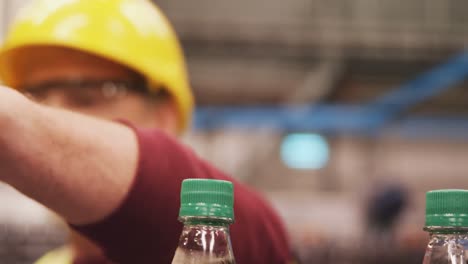 Workers-checking-bottles-on-production-line