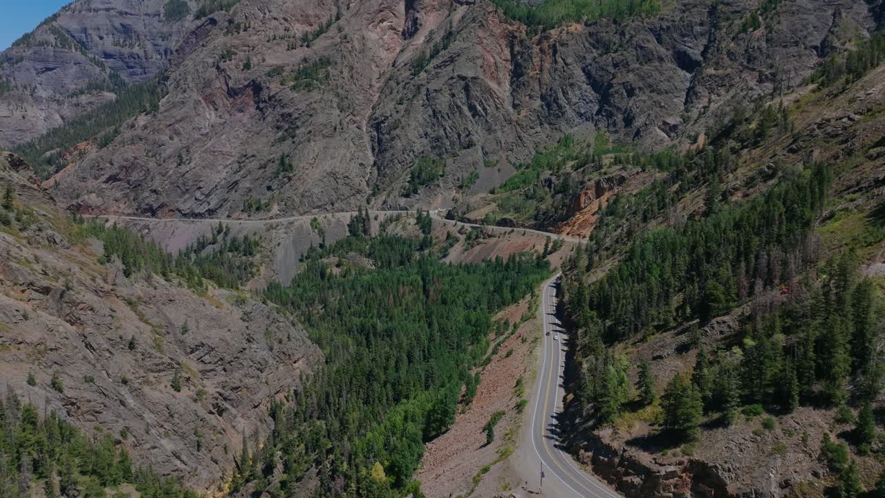 Panoramica aerea elevata di una strada di montagna serpeggiante attraverso il ripido terreno alpino del Colorado, Million Dollar Highway Colorado USA.