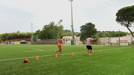 People exercising on a grass field with cones