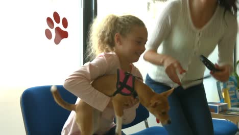 mother and daughter with dog in vet waiting room