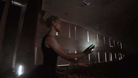 movimiento lento: prima ballet en un vestido negro realiza rotaciones y baila movimientos graciosos ensayando un programa en solitario. la cámara se mueve en gimbal.
