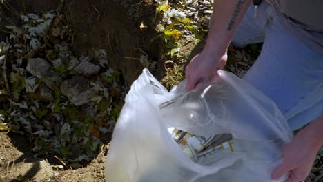 person take secret stash of money from dirt hole, close up view