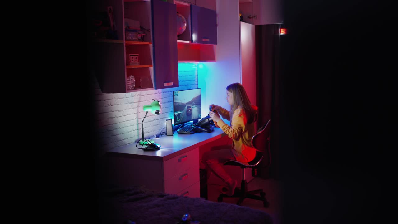 Woman playing on computer. Girl sits in the simulator of a car and playing the game