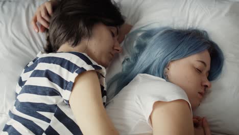 Top-view-video-of-lesbian-couple-sleeping-on-bed.