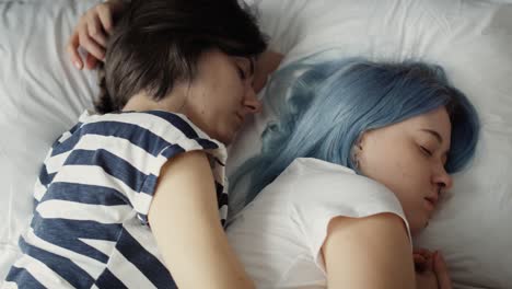 top view video of lesbian couple sleeping on bed.