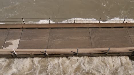 high angle view: flooding river water reaches deck of one lane bridge