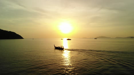 drone following boat with golden sunset on the backgroud