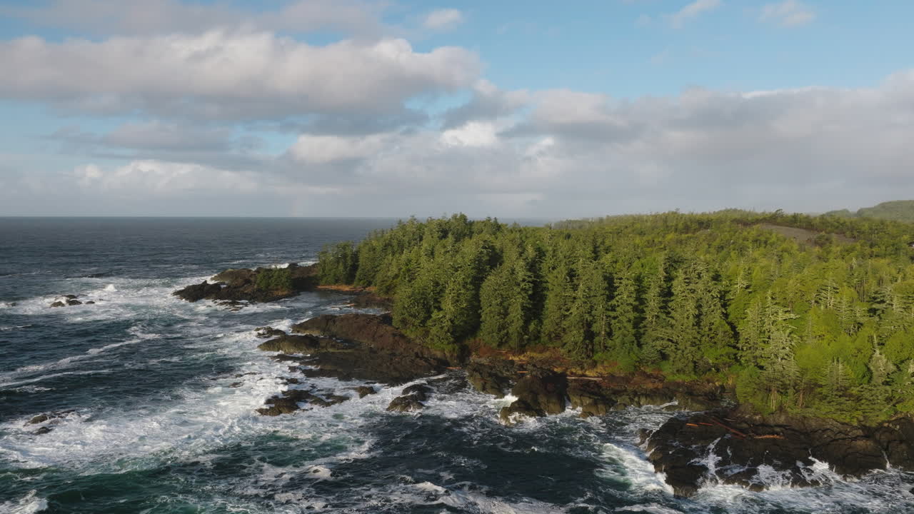 Video drone saat matahari terbenam di Ucluelet, British Columbia, Kanada, di atas samudra dan hutan.