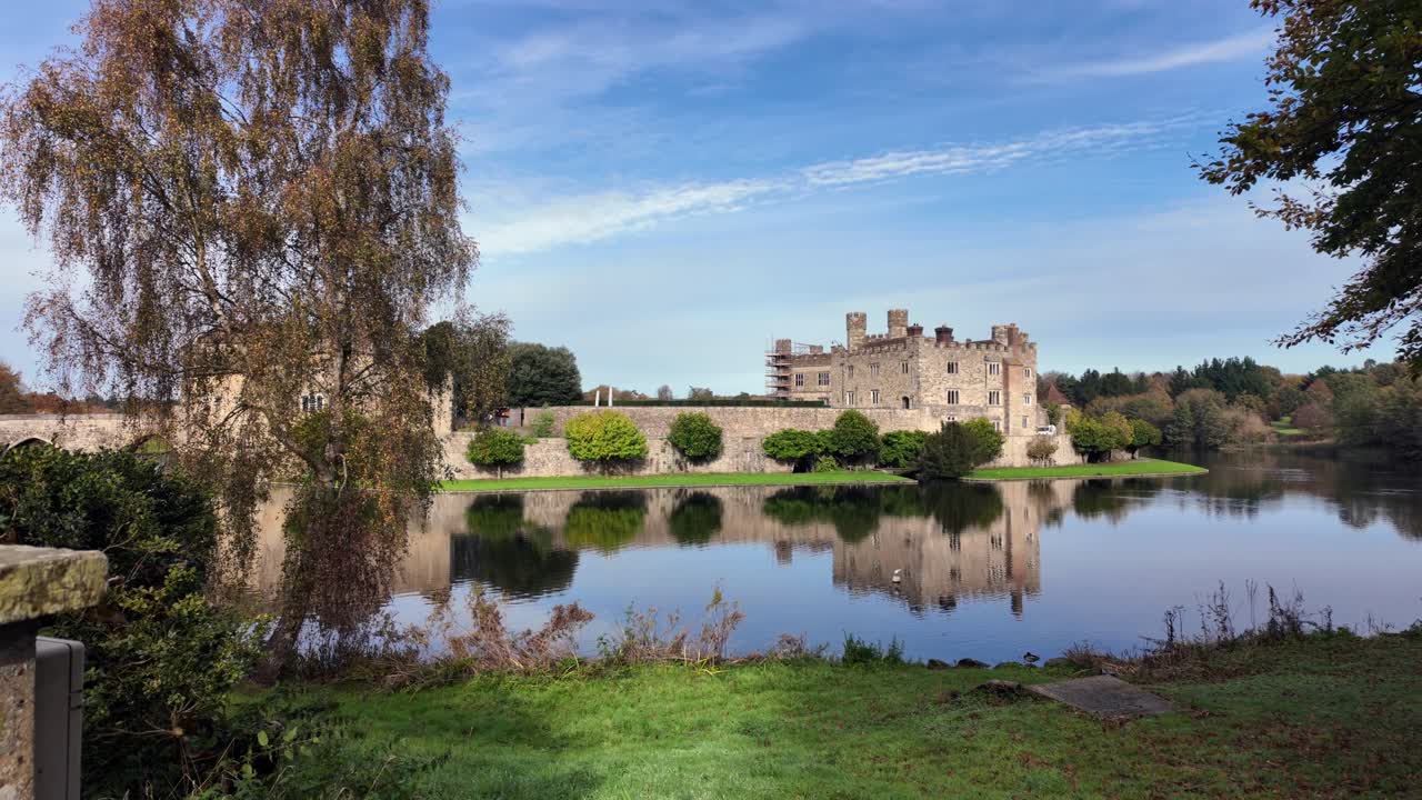 Sakte panorering av Leeds Castle og refleksjon over rolig innsjø om høsten i Storbritannia