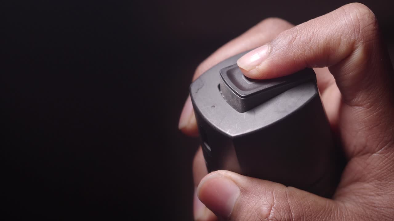 손으로 개인 방어 스프레이를 활성화합니다.