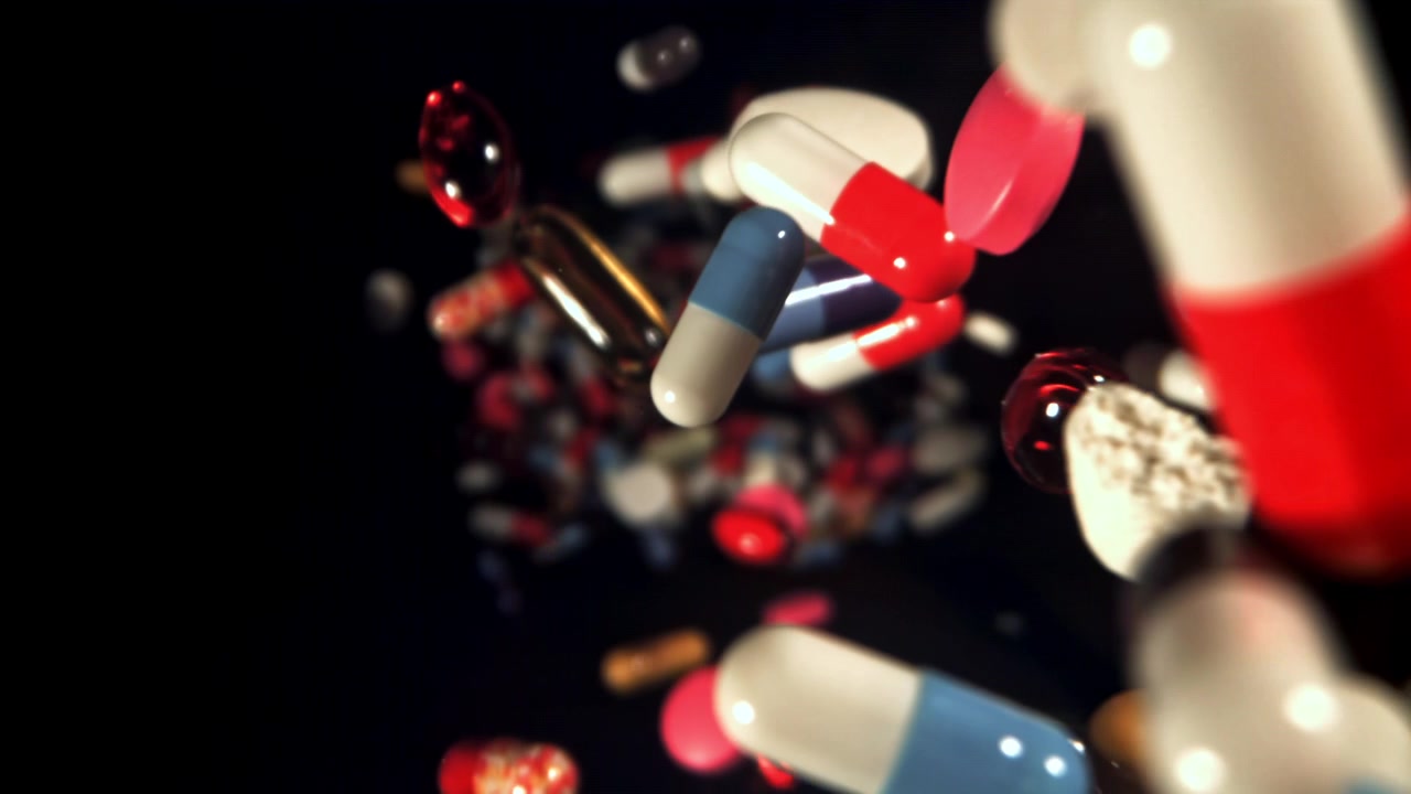 Pillole e capsule colorate che cadono al rallentatore