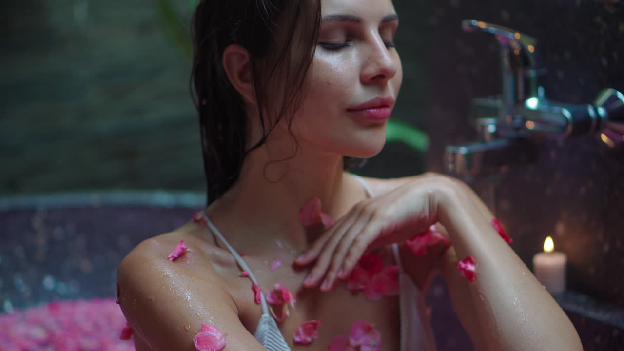 Woman enjoying a romantic spa bath with rose petals