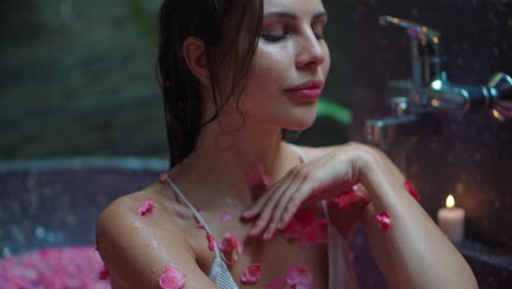 mujer disfrutando de un romántico baño de spa con pétalos de rosa