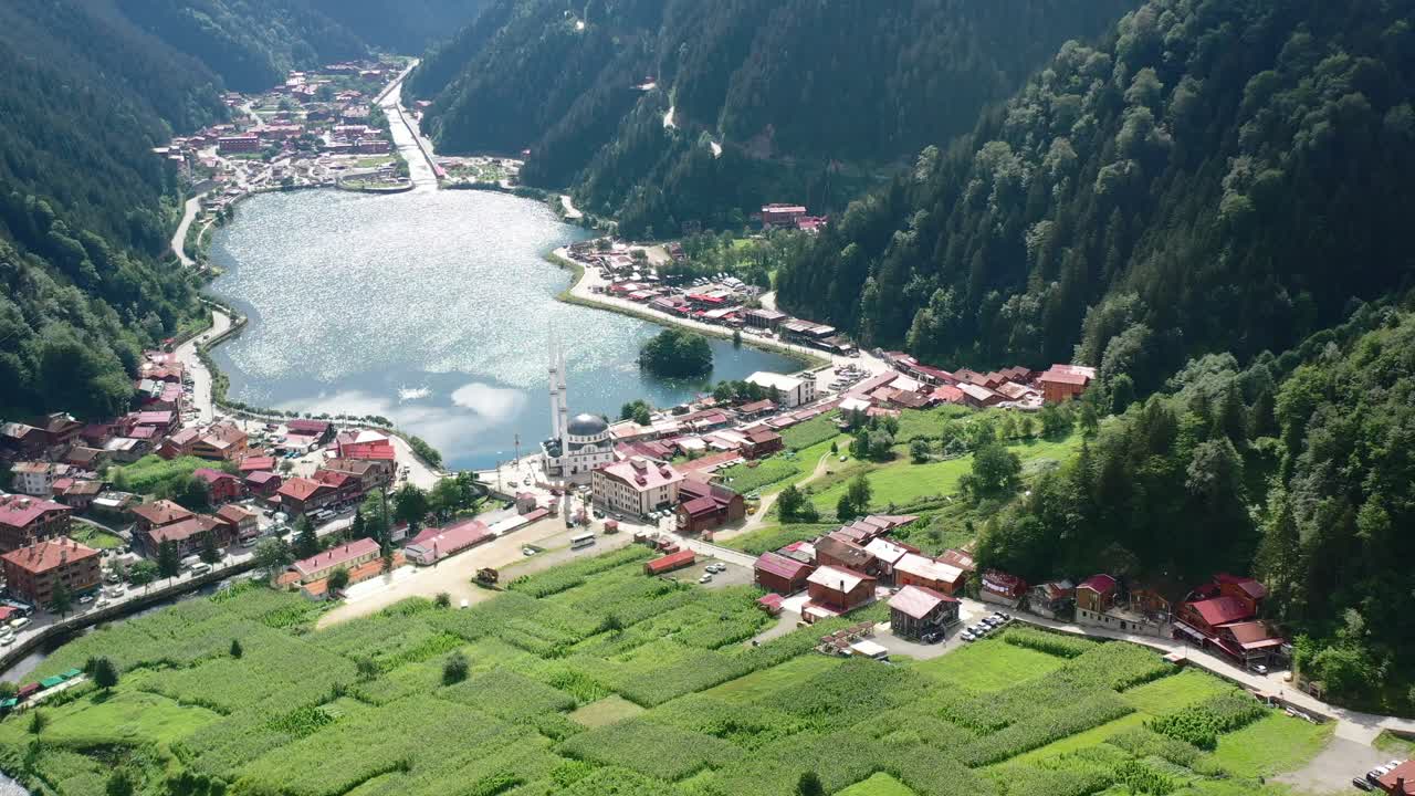 Dronekuva moskeijasta Uzungolissa, Trabzonissa, järven rannalla aurinkoisena kesäpäivänä, kun valo heijastuu taloihin ja vuoriin Turkissa