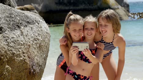 Siblings-taking-selfie-with-mobile-phone-at-beach-4k