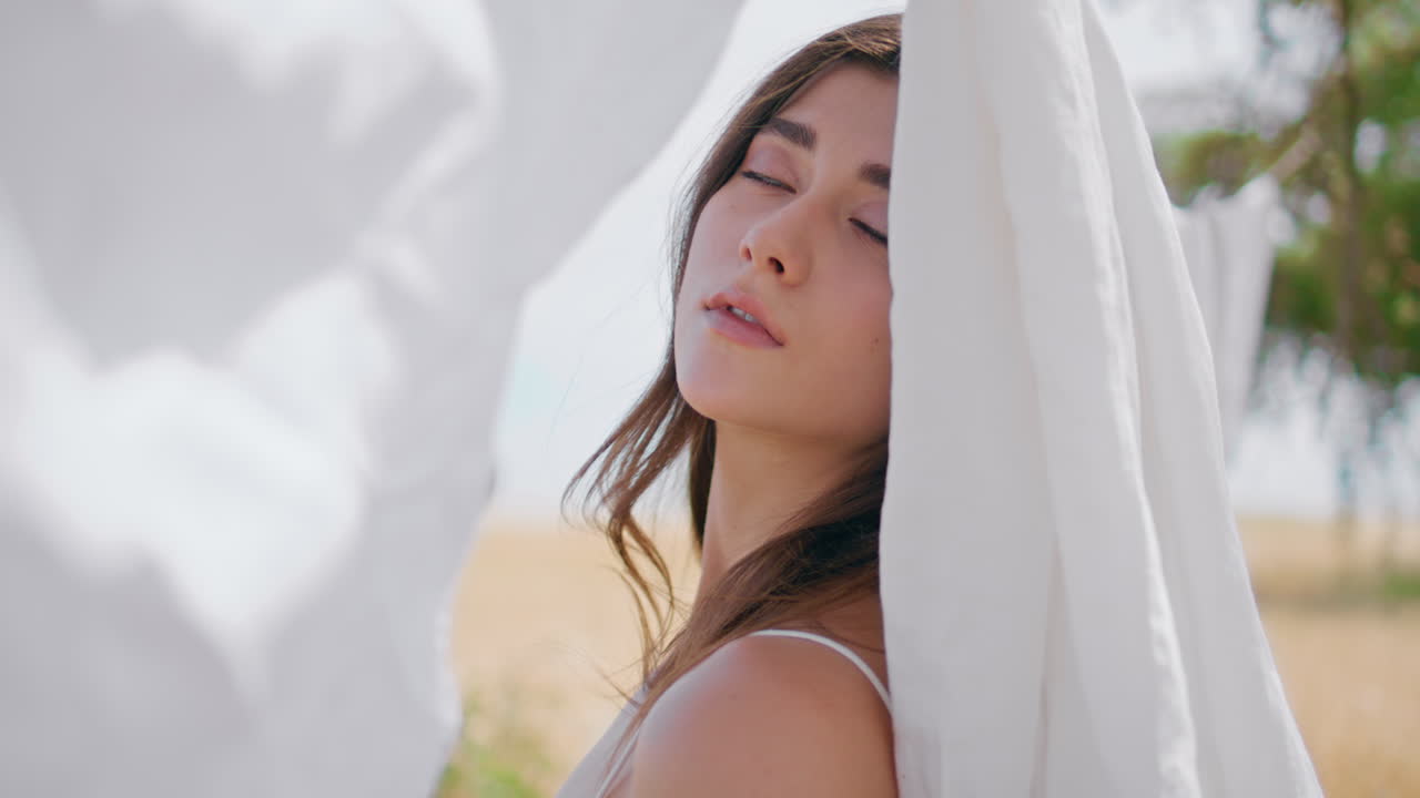 현장 초상화에서 로프에 린을 포즈하는 매혹적인 갈색 여성. 카메라를 찾는 여인