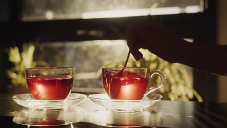 woman prepares morning tea - crushes sugar in a glass cup