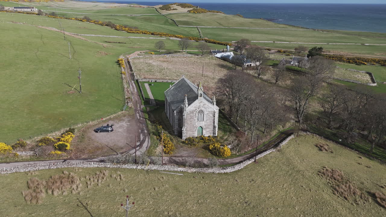 Iglesia de piedra en el cementerio de New Loth en Escocia, rodeada de campos abiertos, un tranquilo paisaje rural.