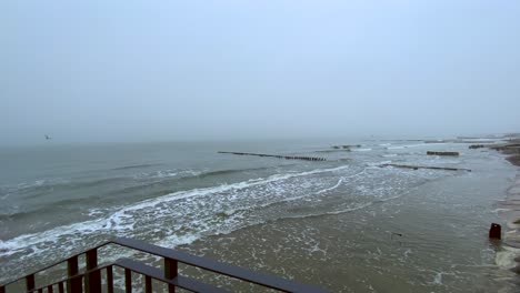 panning of sea and cloudy and cold beach in winter on city of mielno