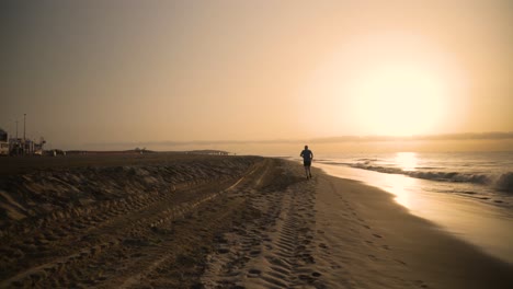 man running on beach at sunrise