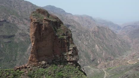 Fantástica-Toma-Aérea-En-órbita-Sobre-Roque-Palmes,-Revelando-Las-Montañas-Cercanas