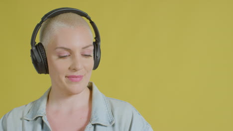 modelo caucásico femenino escuchando música con auriculares retrato de estudio 03