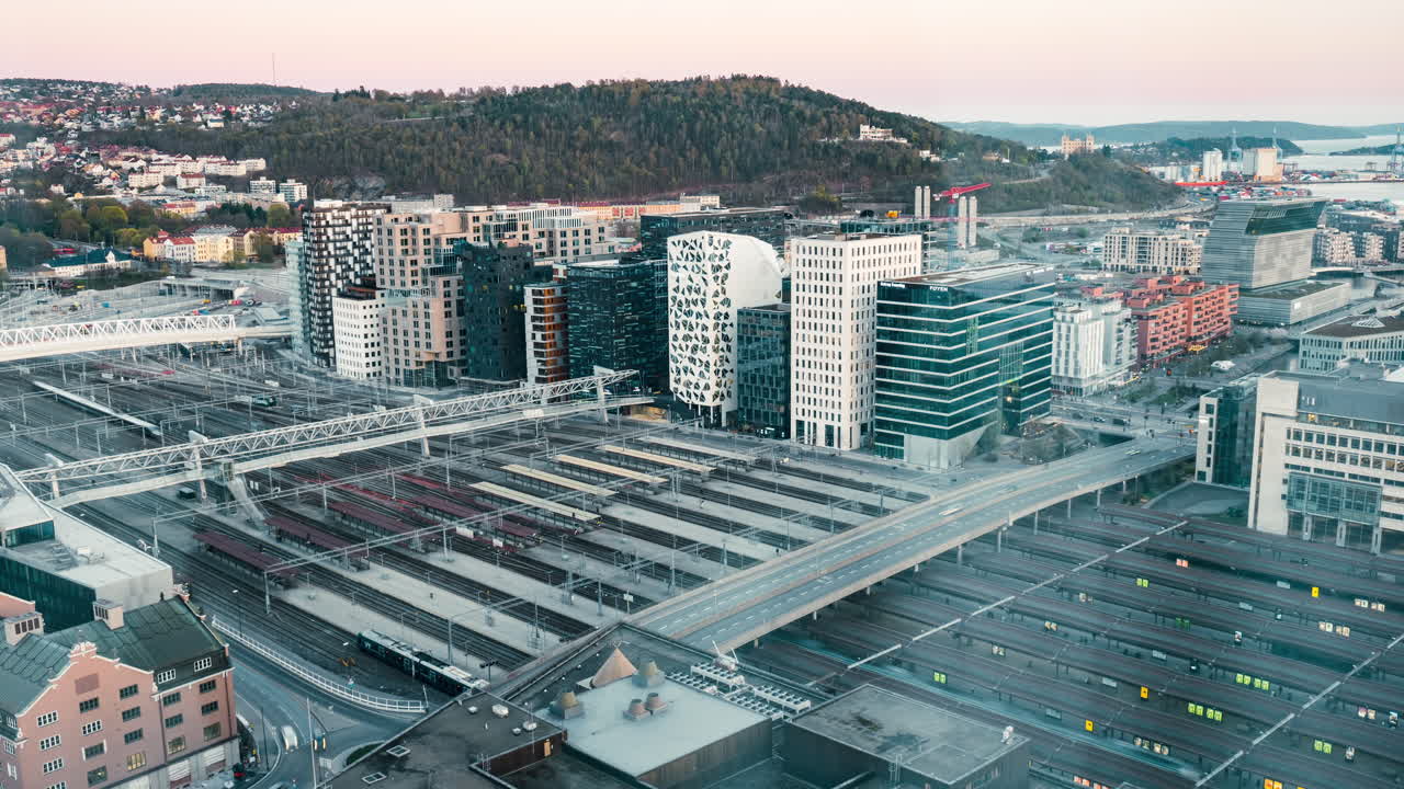 Ankommende und abfahrende Züge am Osloer Hauptbahnhof mit Blick auf das Barcode-Projekt in Oslo, Norwegen.