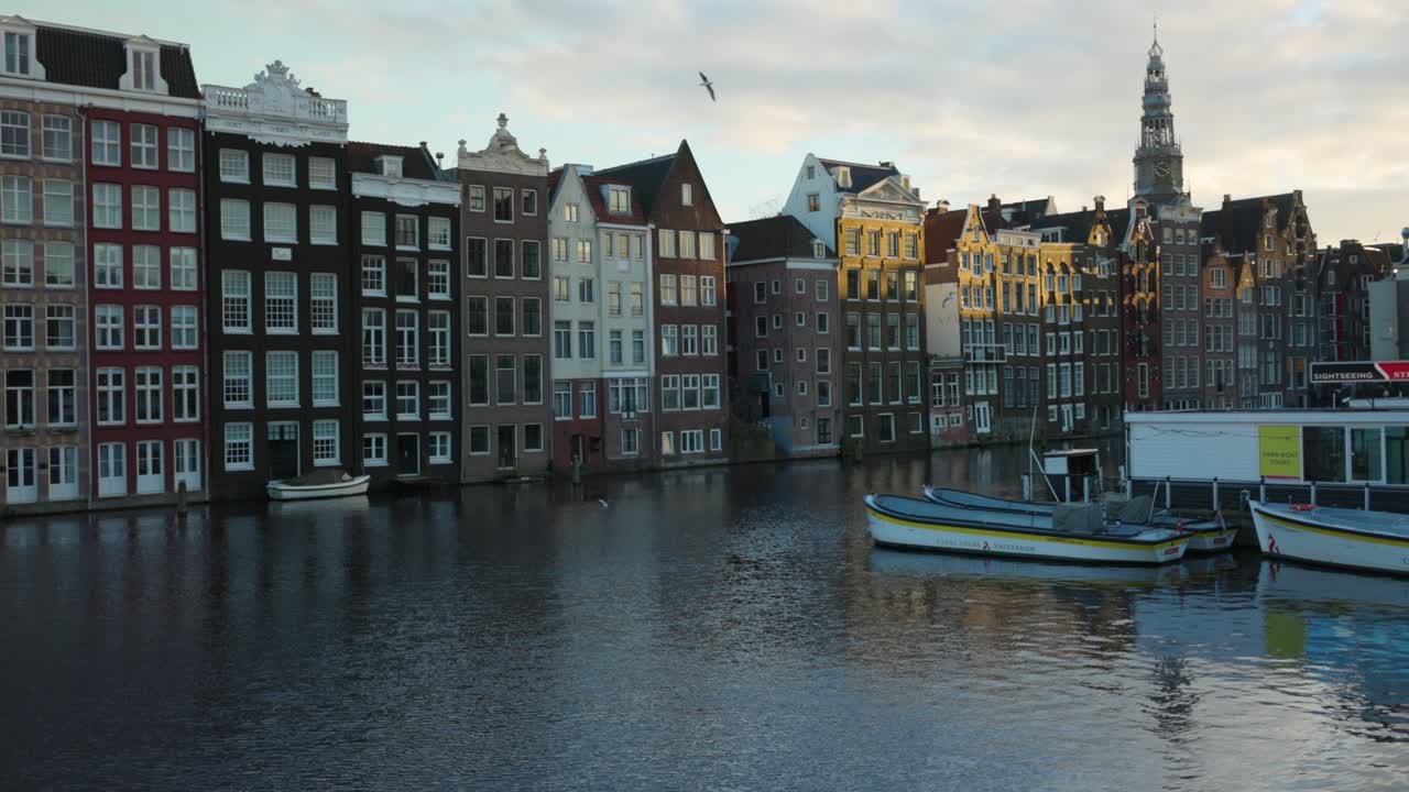 escena icónica del canal de ámsterdam con casas históricas y barcos temprano en la mañana