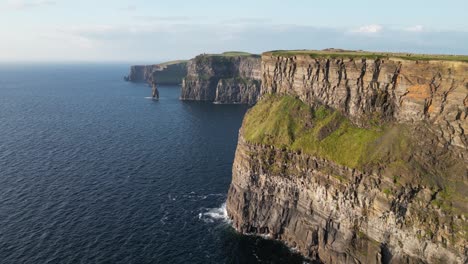 Los-Acantilados-De-Moher-En-Irlanda,-Majestuosa-Maravilla-Natural,-Océano-Azul-Debajo,-Día-Soleado,-Vista-Aérea