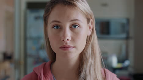 portrait-beautiful-blonde-teenage-girl-in-kitchen-at-home-looking-serious-expression