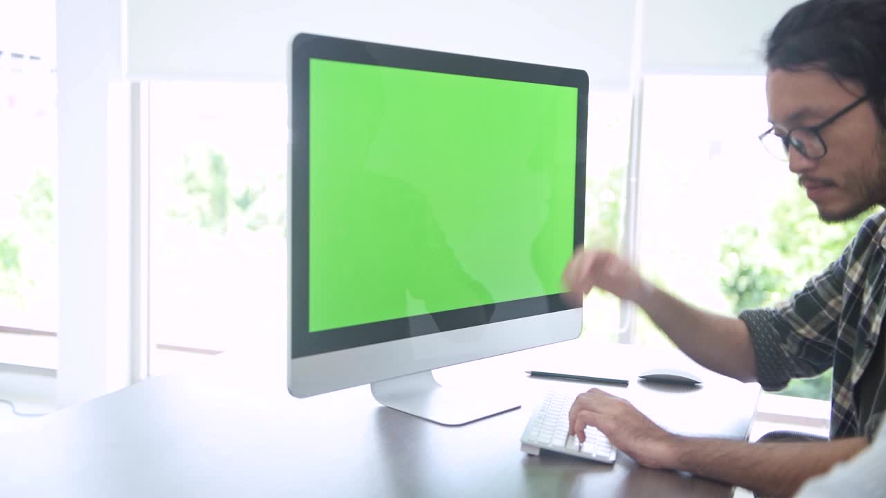 소규모 스타트업 그룹 토론실에서 젊은 아시아 남자가 그린 스크린 컴퓨터에서 자신의 아이디어를 팀에 발표합니다.