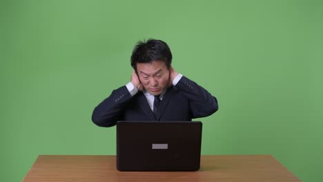 mature japanese businessman against green background