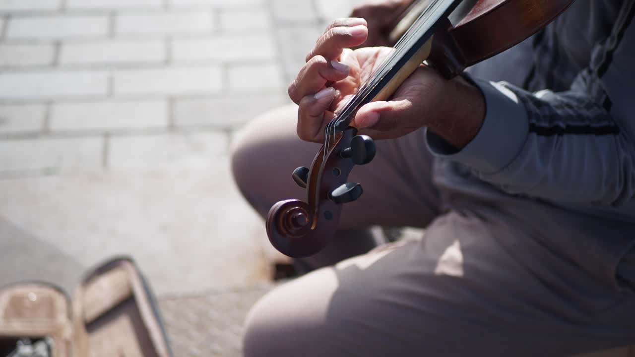 야외에서 바이올린을 연주하는 남자의 클로즈업