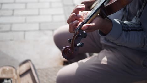 primer plano de un hombre tocando el violín al aire libre