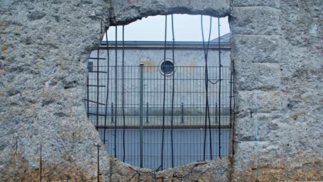 remainings of berlin wall hole with car passing by in baudenkmal berliner mauer