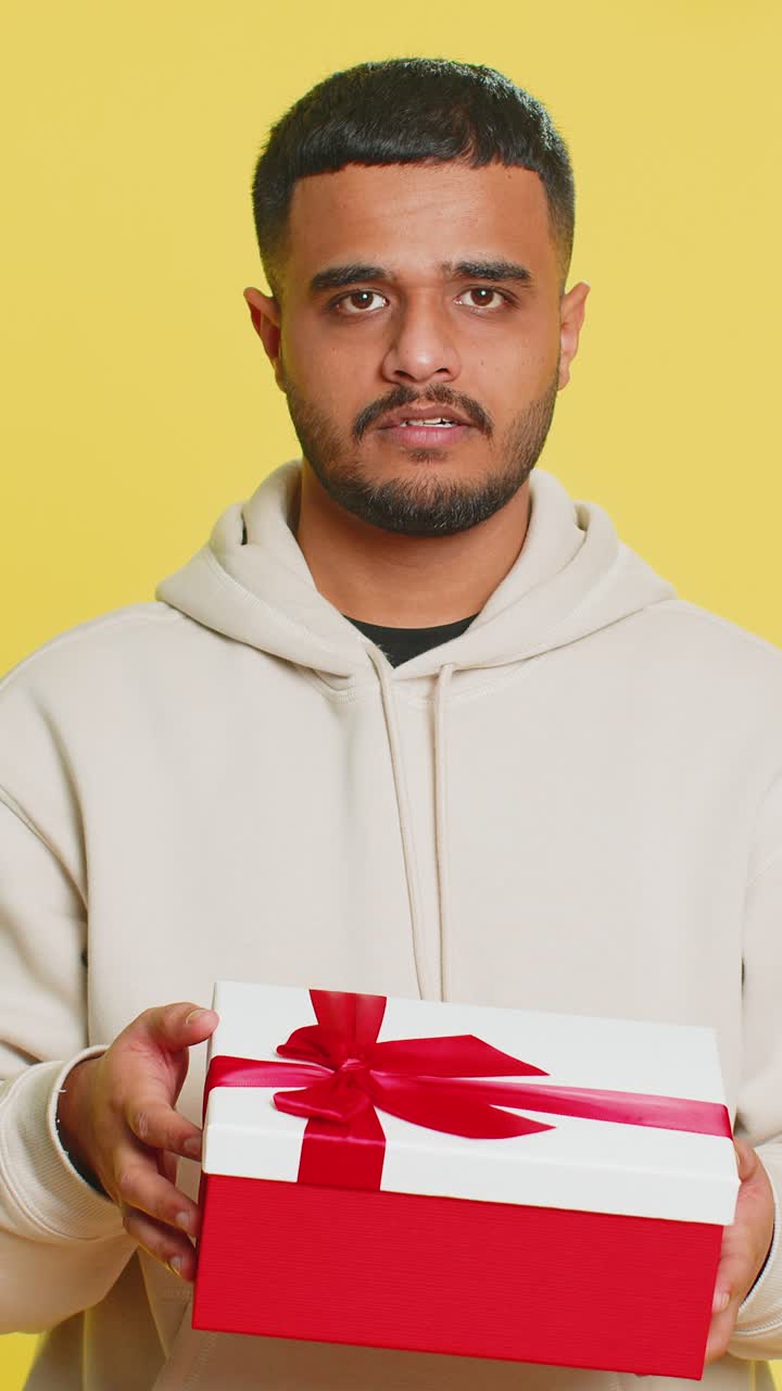 Man opening birthday gift box with red ribbon receiving great present surprise celebrating