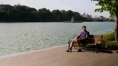 El-Turista-Se-Toma-Un-Tiempo-Para-Relajarse-En-El-Famoso-Lago-Hoan-Kiem,-Hanoi.