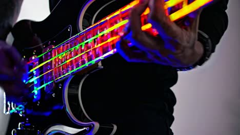 close-up of a bass guitarist playing a glowing bass guitar