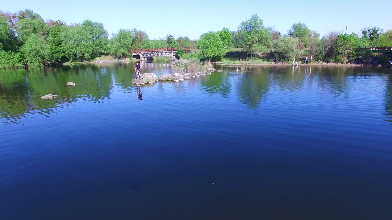 Cyclist on the shore. Traveler with backpack stand on the shore near his bike and enjoying landscape