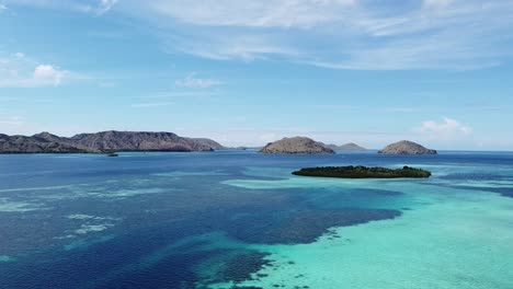 aerial view of tropical indian ocean, showing blue waters, lush islands, and distant mountain ranges in indonesia