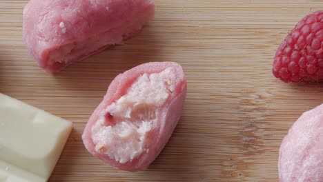 soft pink mochi filled with strawberry and white chocolate, sliced open to reveal the creamy filling