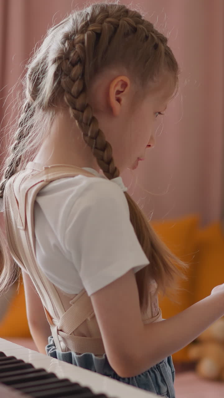 Elder sister with back supporting corsage tries to teach little brother to play digital piano at home. Toddler boy disinterested in musical lesson