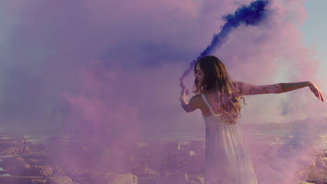 Hermosa-Mujer-Bailando-Con-Una-Bomba-De-Humo-Púrpura-En-La-Playa-Celebrando-La-Expresión-Creativa-Con-Un-Baile-Juguetón-En-Cámara-Lenta