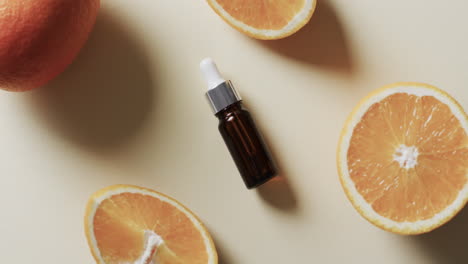 video of make up bottle with pipette, citrus slices and copy space on yellow background