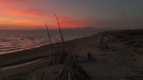 Treibholz-Tipis-Am-Sandstrand-Bei-Sonnenuntergang