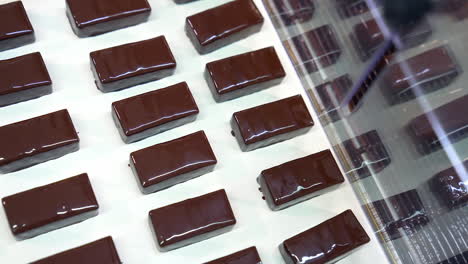 manufacture of chocolate bars. ready-made candies move along the conveyor belt. sweet desserts enterprise. close up.